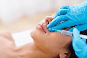 Frau bekommt Lippen mit Hyaluron-Kanüle aufgespritzt.